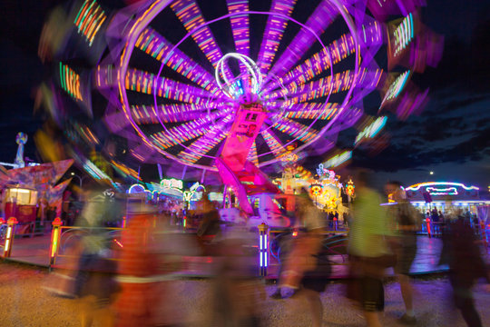 verwischte Menschen vorm Karussell nachts Kirmes