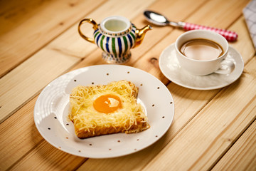 breakfast set with coffee and toast with egg on wooden table
