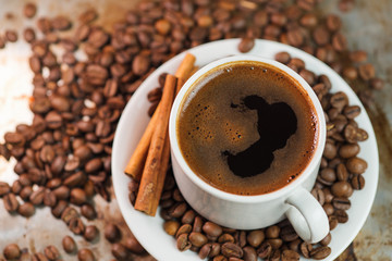 Close - up of a white Cup of coffee in coffee beansClose - up of a white Cup of coffee in coffee beans