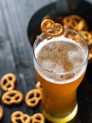 A glass of wheat beer and a traditional pretzel appetizer on the table