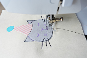Free motion embroidery process: cute cat in party hat applique and sewing machine