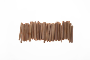 Many wooden ice cream sticks in row on white background isolated, flat lay