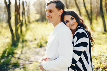 Fototapeta premium bright and happy pregnant woman walking in the park with her husband