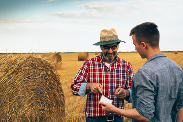 two ranchers talking outdoor on wheat field