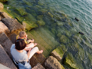 bare feet of a woman and a child by the water