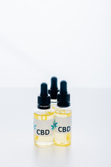 cannabis oil in bottles with lettering cbd on white background