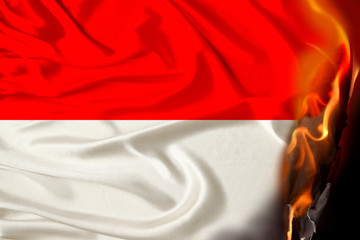 orange flames and ashes on a colored burning national flag of the state, concept of danger,...