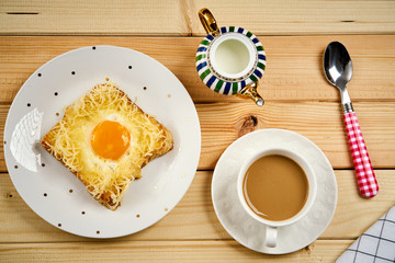 breakfast set with coffee and toast with egg on wooden table