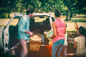 Foto op Plexiglas Family placing picnic items in car trunk © vectorfusionart