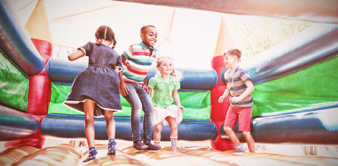 Friends playing on bouncy castle at playground