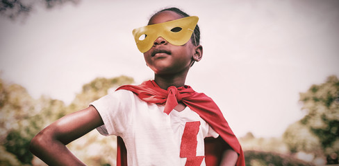 Cute girl pretending to be superhero with hands on hip - Powered by Adobe