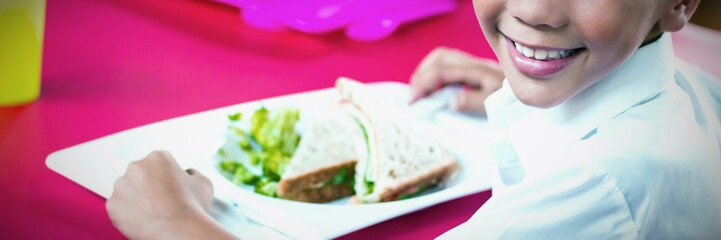 Children having lunch during break in cafeteria
