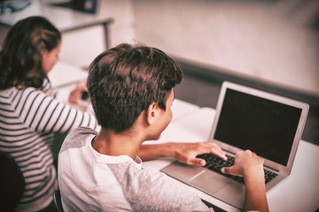 Student using laptop in classroom