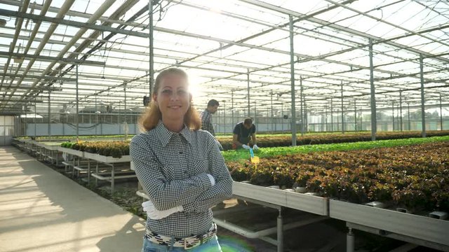 Portrait of female agronomist engineer smiling in a greenhouse with modern agriculture technology.