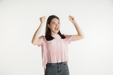 Obraz premium Beautiful female half-length portrait isolated on white studio background. Young emotional woman in casual clothes. Human emotions, facial expression concept. Celebrating like winner, looks happy.