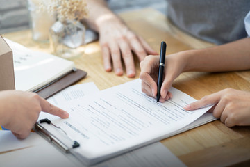Woman putting signature on document loan contract, real estate purchase, hands of woman sale...