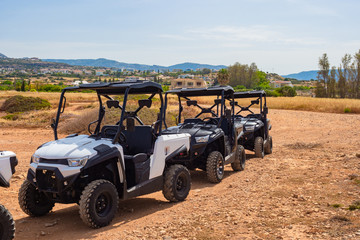 UTV. ATVs stand in a row.Quad bike with a roof. ATVs for travel. Off-road driving on a quad bike. Trips in Cyprus. The surroundings of Paphos. White stones. Rent UTV.Mediterranean Sea Tourism. Buy UTV © Grispb