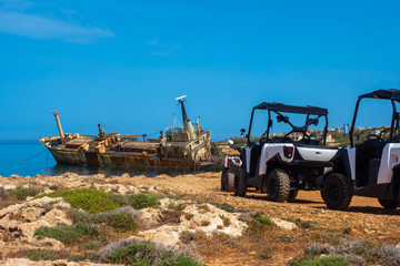 Pathos. ATVs in Cyprus. Motorcycle on the background of a sunken ship. Quadrocycles are on the beach. Skeleton of a ship next to the city of Paphos. Quad bike in the sand. Cyprus.Mediterranean Sea.UTV