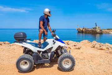 Cyprus. The city of Paphos.Sports ATV on the coast of Cyprus. Athlete admires the sunken ship.ATV rides along the beach. The skeleton of the ship off the coast of Cyprus.Quad bike ride on white stones