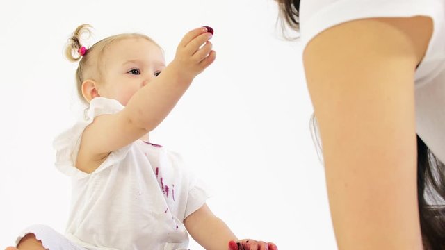 Smudged baby girl treats her mom with berries