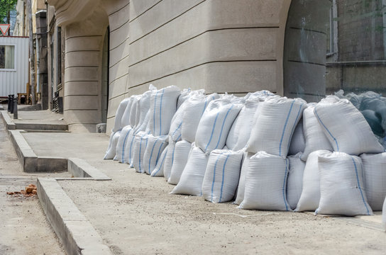 Lots Of Bags Of Cement Or Sand Near The Wall For Building Or Laying Tiles Close Up