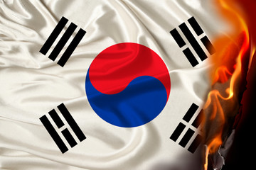 orange flames and ashes on a hot national flag of the state of South Korea, the concept of...