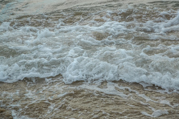Fototapeta na wymiar background of waves beating on a sandy beach in stormy weather