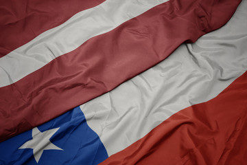 waving colorful flag of chile and national flag of latvia.