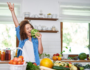 Happy woman singing while cooking a meal