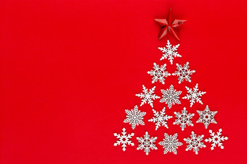 Fototapeta na wymiar White snow flake decoration on red background. Flat lay, top view