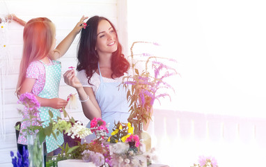 A young girl with a daughter is picking up a bouquet. A young mother with her daughter makes a...