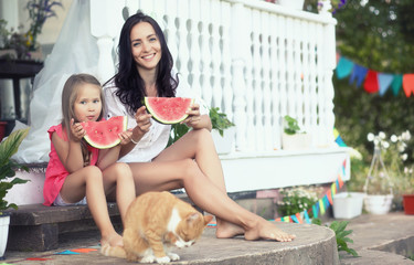 Young family eating a juicy red watermelon
