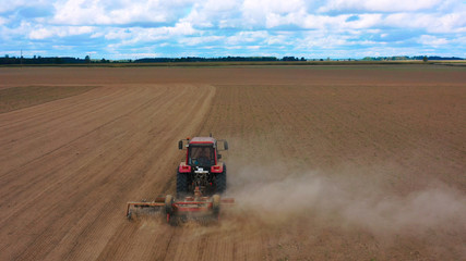 Obraz premium Aerial view drone of harvest field with tractor mows dry grass. Autumn yellow field with a haystack after harvest top view. Harves. Ting in the fields. Stock up