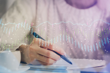 Forex chart displayed on woman's hand taking notes background. Concept of research. Multi exposure