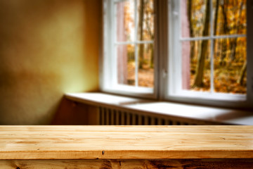 Wooden desk of free space and autumn window background 