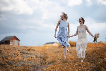 Two girls in dresses in autumn field