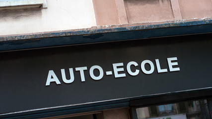 Fototapeta premium Closeup of driving school signage in french ( auto ecole) on building facade