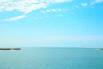 background of blue sky with beautiful clouds and a small part of the azure sea in the frame. the focus is selective.