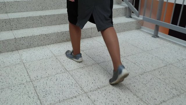 a young woman in sneakers is on the tile at the Mall . legs close up.