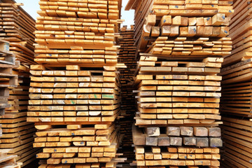 Stack of log preparing for construction. Wooden planks for construction are sold in market.