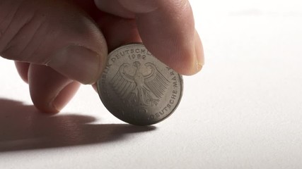 Hand holding 2 Deutsche Mark coin currency of Federal Republic of Germany. Obverse side showing eagle, emblem of Germany.