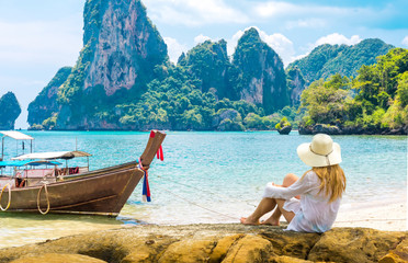 Beautiful woman on paradise Ao Nang Krabi Thailand beach with llongtail boat. Adventure, travel, relax, holiday, vacation, luxury concept. - obrazy, fototapety, plakaty