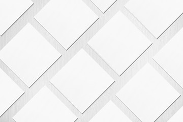 Many empty white square business card mockups with soft shadows lying diagonally on neutral light...