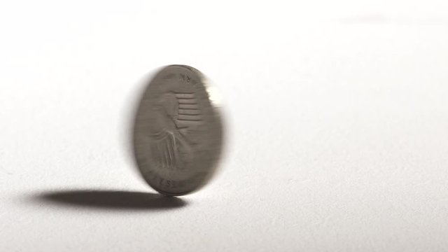 2 Deutsche Mark coin spinning and dropping on desk. Official currency of Federal Republic of Germany.