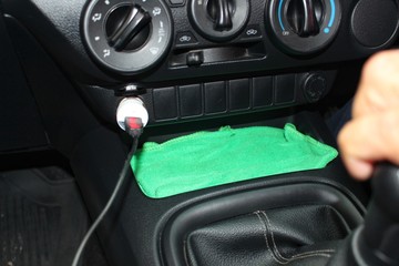 The driver is charging the phone while in the car by taking a blurred photo