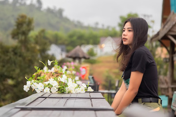 Asian woman dressed in black is watching the sunrise in the morning in Phetchabun province, Thailand. Travel with family concept.