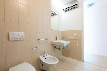 Bath with modern beige tiles, new sanitary fixtures
