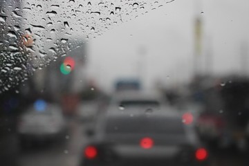 Water droplets on the windshield are on the road while heavy rain shoots blur 