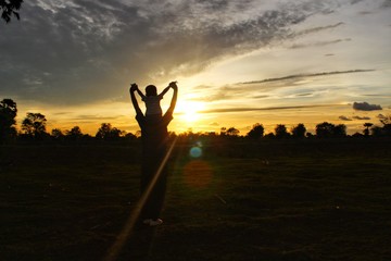The silhouette of the mother and son on playing joyfully, the golden-yellow sky at sunset, Take a blur