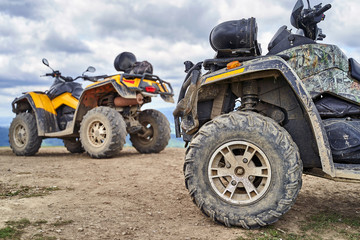 Twi quadricycles or quad bikes on the mountains background on a cloudy day
